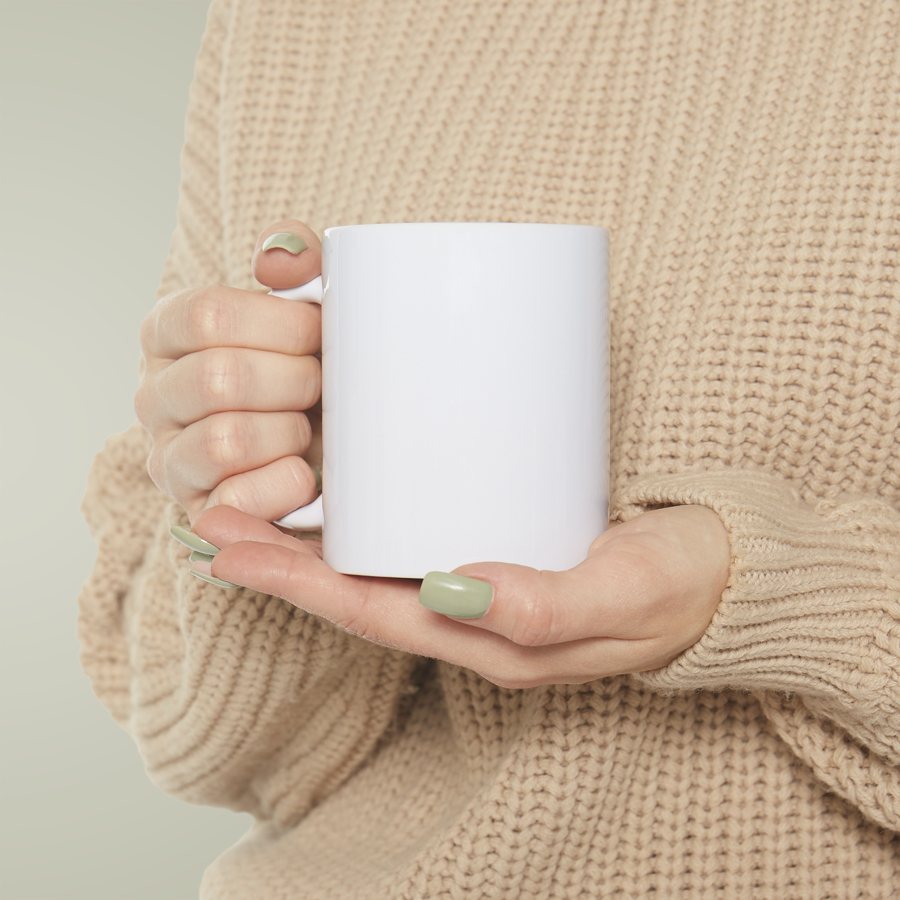 Hand holding a blank white mug